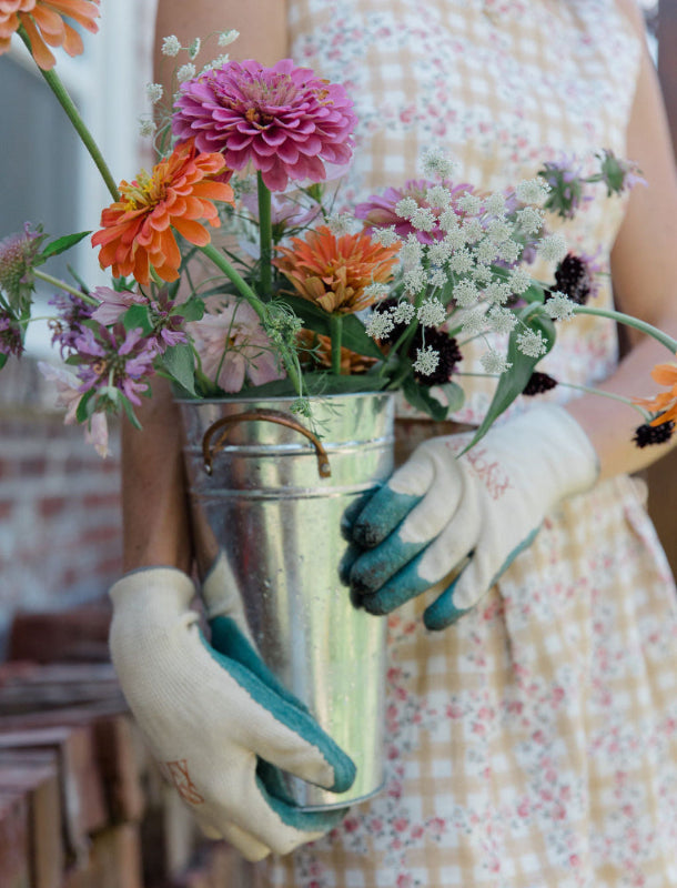 cut flowers held by a gardener with garden gloves on