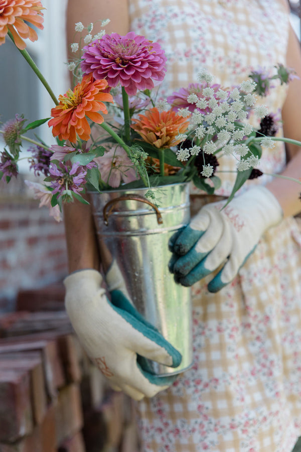 eco-friendly garden gloves holding cut flowers from the garden